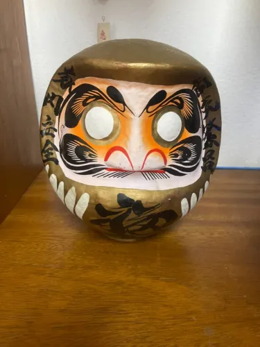 Boneca Daruma Dourada