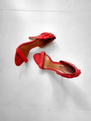 Sandália vermelha com laço, salto fino e elegante.