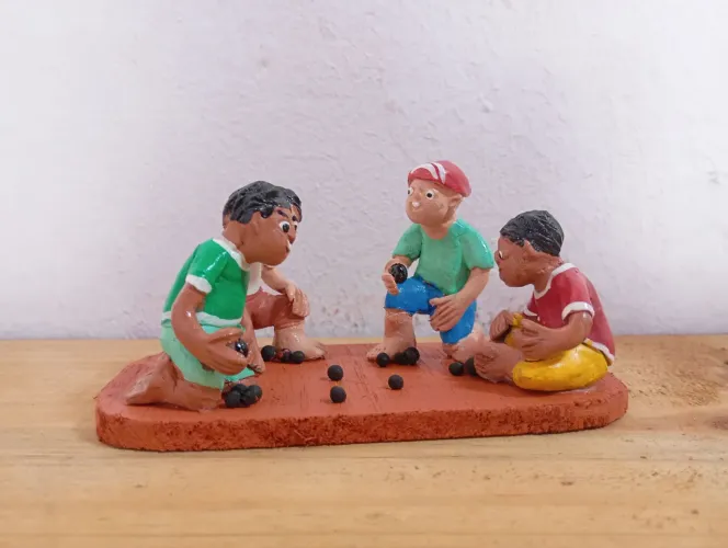 Escultura de crianças jogando bolinhas de gude
