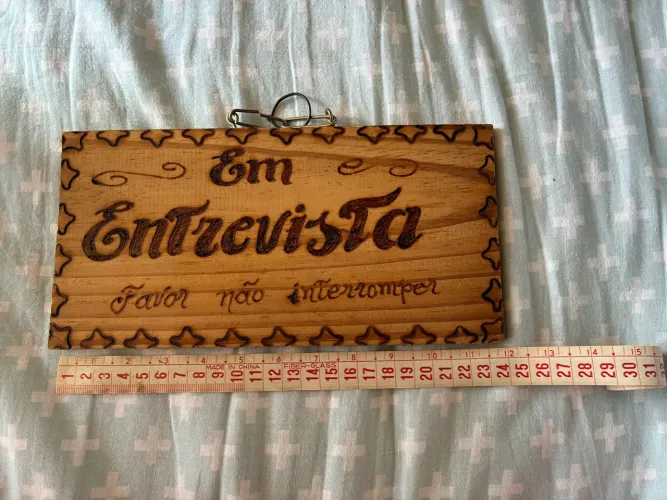 Placa de madeira ?em entrevista/em teste? para escritório