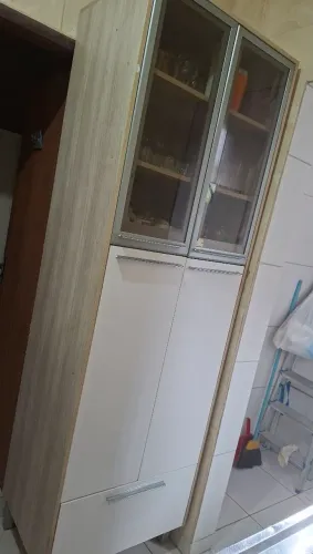 Armário com porta de vidro na parte superior, duas portas inferiores e um gavetão.