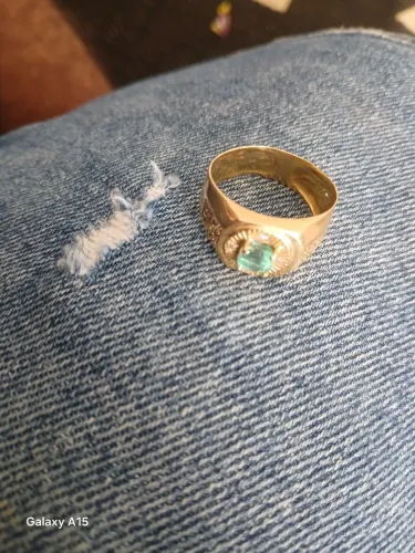 Anel de ouro com uma pedra de ismeralda e cravejada com diamante