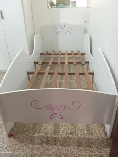 Cama infantil, branca com desenhos na cor rosa. Inclui colchão.
