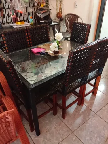 Conjunto de mesa de jantar com tampo de vidro e cadeiras em fibra trançada