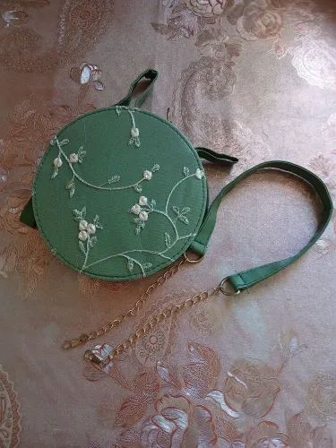 Bolsa verde bordada redonda com alça transversal removível