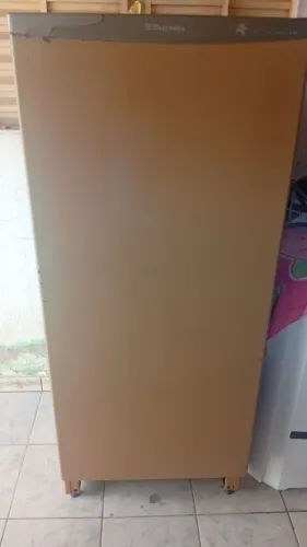 Geladeira antiga está funcionando e uma bicicleta