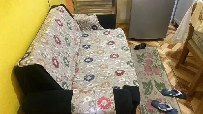 sofá retrátil de 2 lugares revestido em tecido preto ou suede escuro.