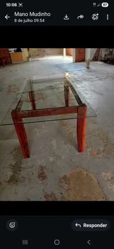 Uma mesa de madeira com o assento de vidro. Novinha só que não tem as cadeiras.
