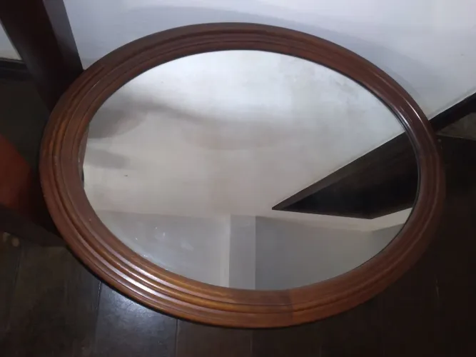 Espelho oval com moldura em mogno. 60 x 80.