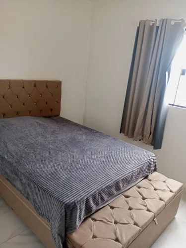 Cama de casal, com cabeceira e baú.
