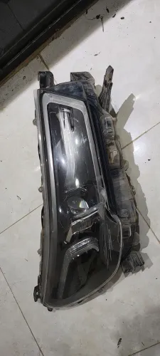 Farol Hilux 21/24 original LD (com lente quebrada)