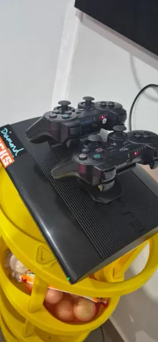 PS3 Super Slim desbloqueado, acompanha 2 controles + 8 jogos físicos.