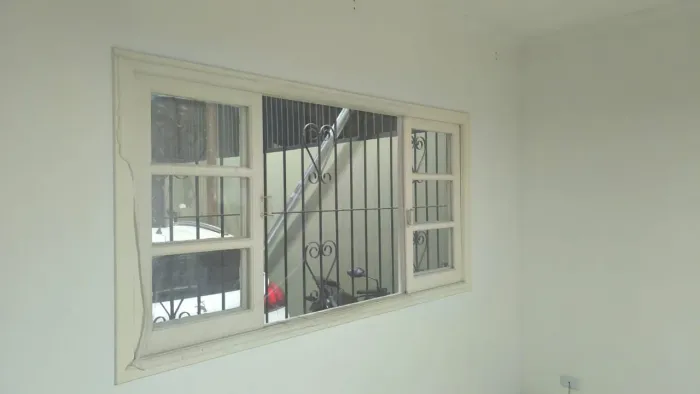 Vendo essa janela madeira com a grade.