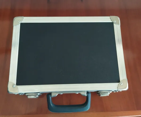 Maleta de transporte preta com fecho de metal e cadeado com senha.