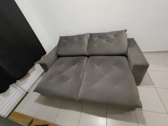 Sofá retrátil e reclinável cinza.