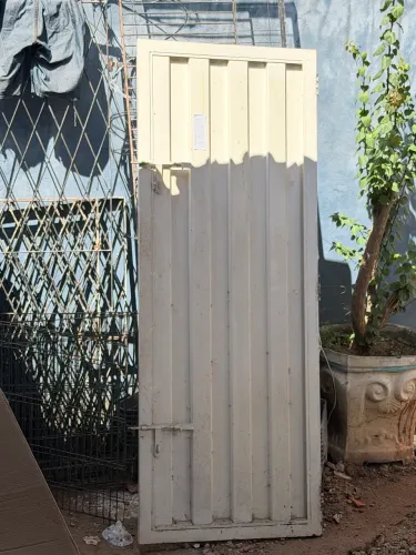 Porta de ferro pouco tempo de uso pesada boa para proteção com ferrolho e portal