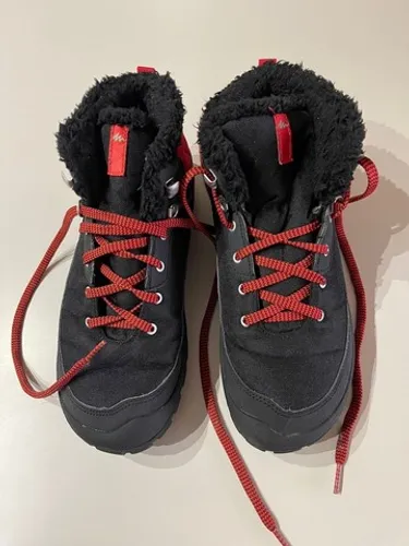 Bota preta com detalhes em vermelho da Decathlon seminova 