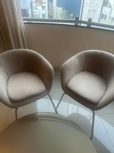 Par de poltronas estilo concha, com estofado e pés cromados em aço. 