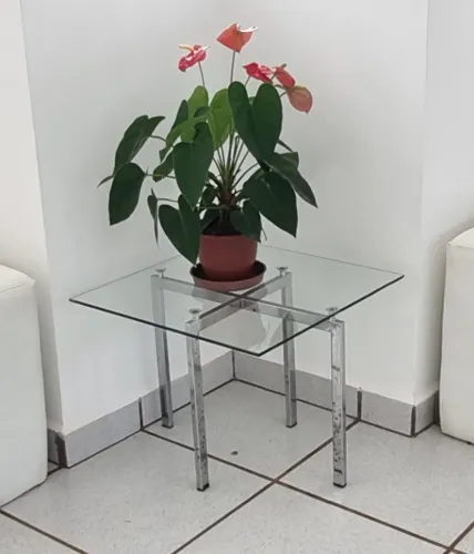 Mesa de canto com estrutura cromada e tampo de vidro