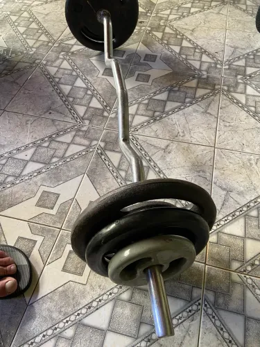 Kit barra W maciça com 34 kg em anilhas.