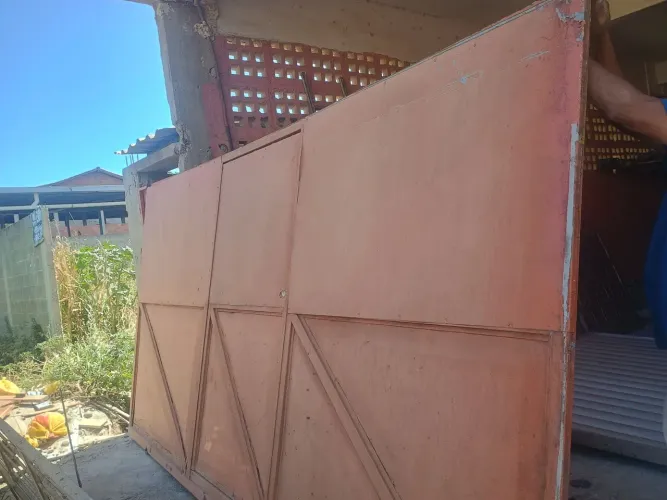 Vendo um portão grande com social no meio 