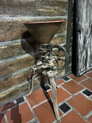 Moinho de grãos e sementes manual de ferro fundido antiquado com funil de cobre