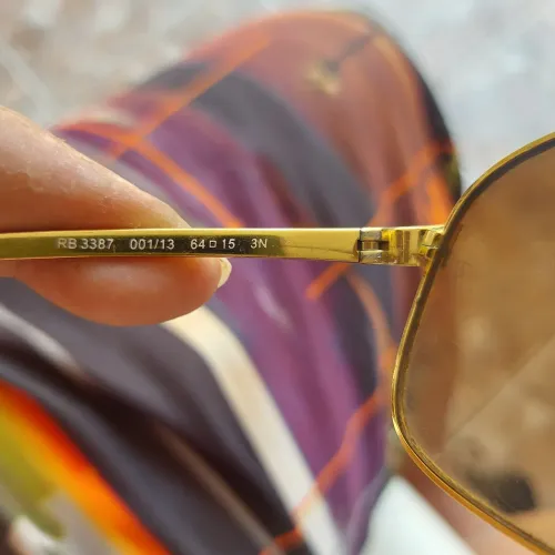 ray ban modelo rb 3387 001/13 64 lente marrom estrutura dourada.