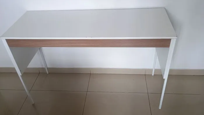 Escrivaninha branca com detalhes amadeirados.