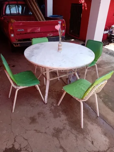 Mesa redonda com pedra de mármore branco  conservada,com 4 cadeiras em bom estado .