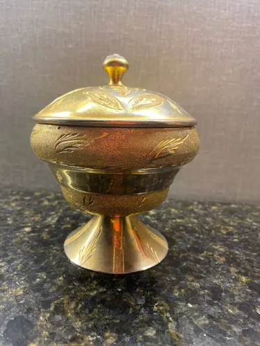 bomboniere com cena das folhas em metal dourado e estilo árabe.