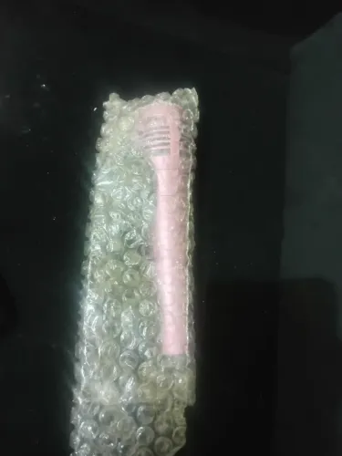 Microfone rosa novo no plástico e cabo.