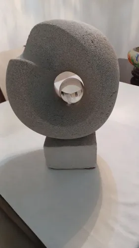 Escultura abstrata em pedra pome com esfera de vidro