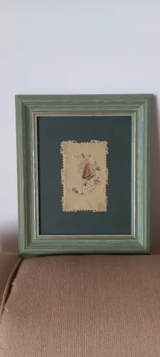 Quadro em moldura verde de cartão antigo com desenho em relevo.