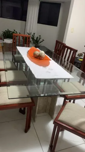 Mesa com 8 cadeiras e buffet.