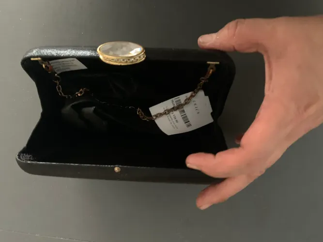 Bolsa de festa preta com leve textura e fecho estilizado com 2 alças 
