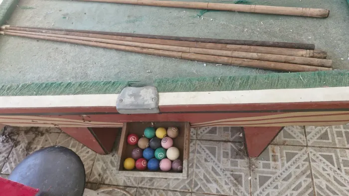 Mesa de sinuca com bolas e tacos