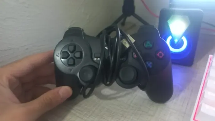 Controle joystick de videogame, especificamente o modelo DualShock 2 para o PlayStation 2