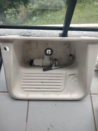 Um tanque de lavar roupa, com torneira.