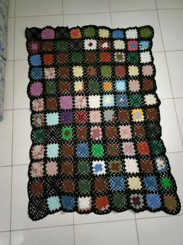 Uma mantinha para sofa de croche colorida