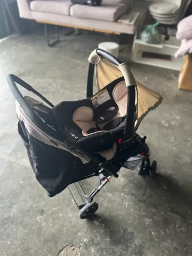 Carrinho de bebê cosco com bebê conforto e base para veículo.