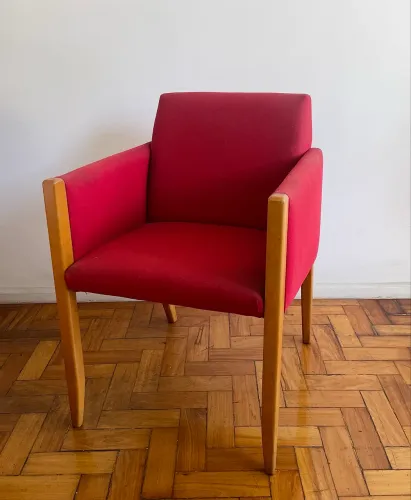 Poltrona vermelha com detalhes em madeira