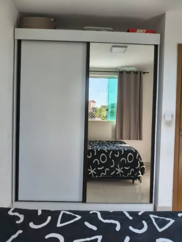 Guarda roupa com duas portas de correr uma porta com espelho gigante.