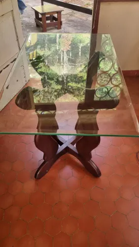 Mesa com tampo de vidro e pés em madeira com design diferenciado