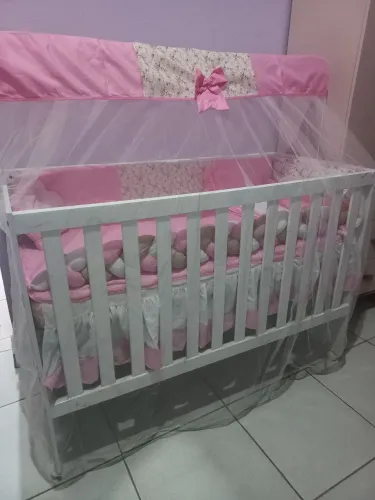 Um berço completo com enxoval e colchão