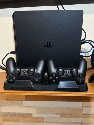 PlayStation 4 Slim com 3 controles dualshock, base carregadora e com 14 jogos incluídos.