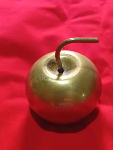 Mini porta joias em metal em forma de maçã.