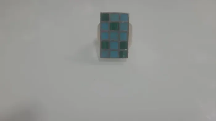 anel em prata  retangular  com um design de mosaico/xadrez de pedras turquesa em dois tons