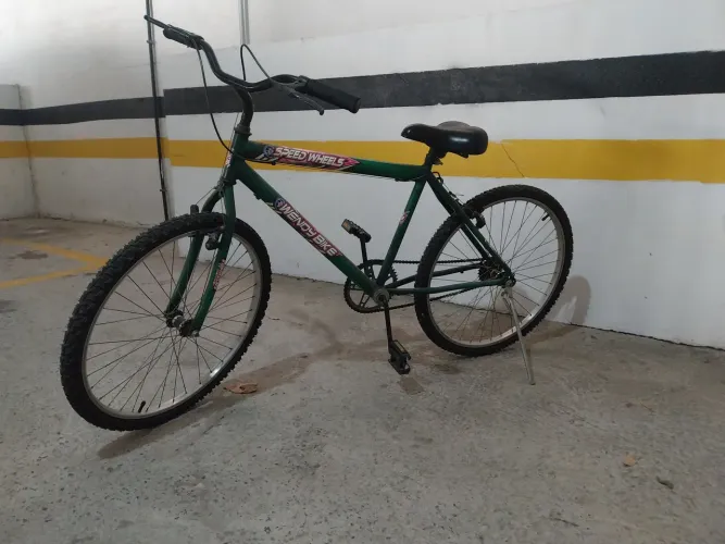 Bicicleta verde em bom estado com pé de apoio já montada