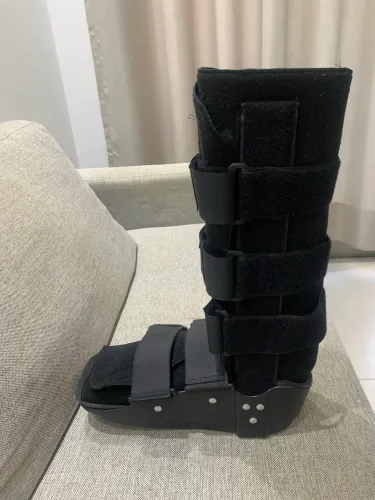 Bota ortopédica e par de muletas