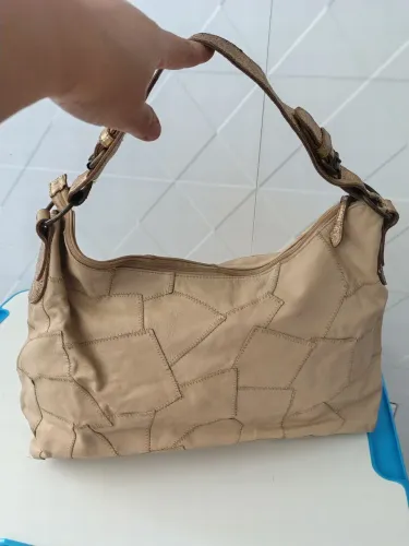 Bolsa em couro bege com recortes e detalhes em ouro velho 